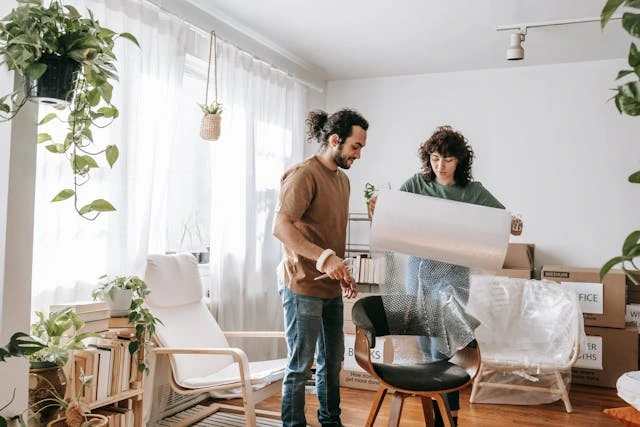 Couple Wrapping A Chair With Bubble Wrap Couple Wrapping A Chair With Bubble Wrap