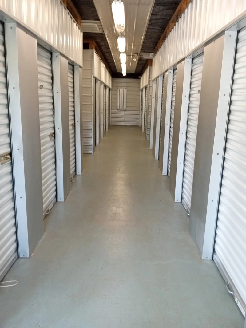 A long hallway lined with storage units in a self-storage facility, showcasing organized and accessible storage options A long hallway lined with storage units in a self-storage facility, showcasing organized and accessible storage options